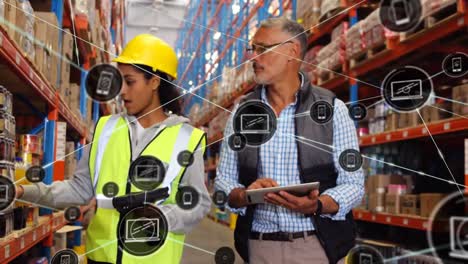 Animation-of-network-of-icons-over-diverse-male-supervisor-and-female-worker-discussing-at-warehouse