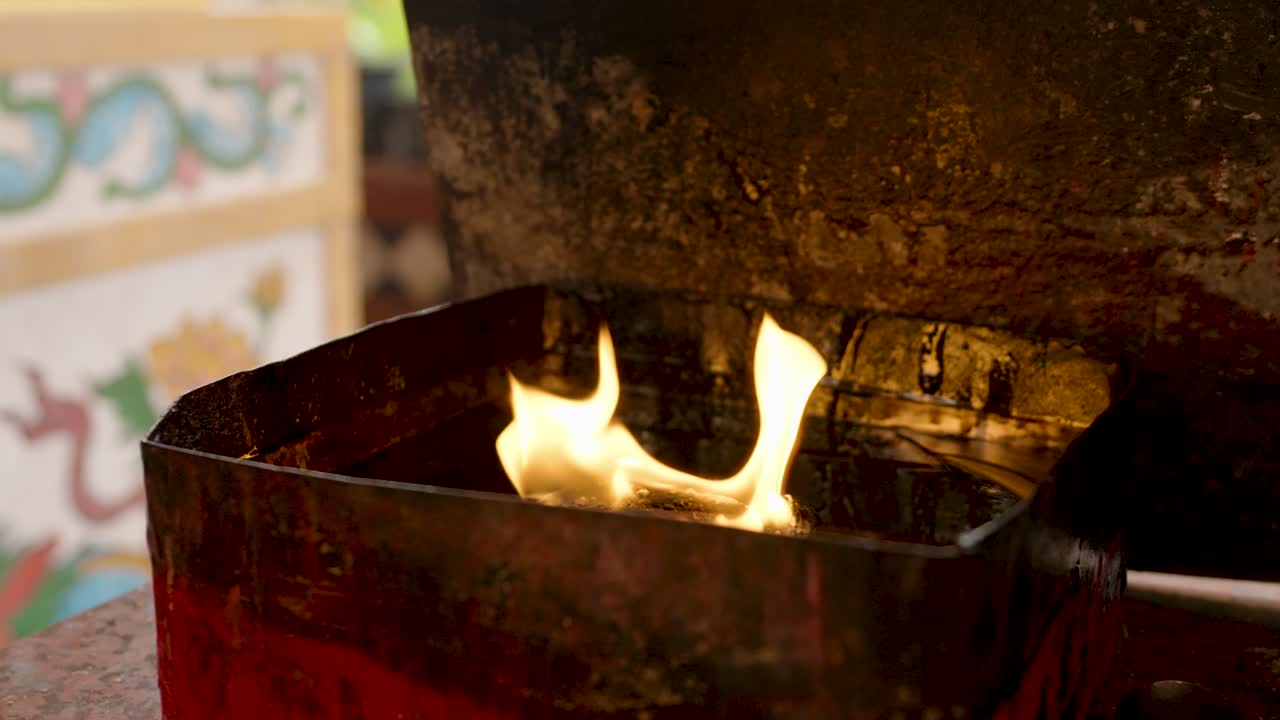 4k, Lighting a fire in an oil furnace to wait for tourists to bring incense and candles to burn at a Chinese shrine to pray to the gods
