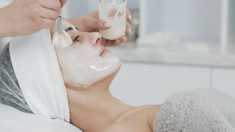 Woman receiving facial mask treatment at spa