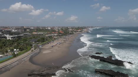 quiet morning aerial, few tourists on sandy canggu beach on bali coast