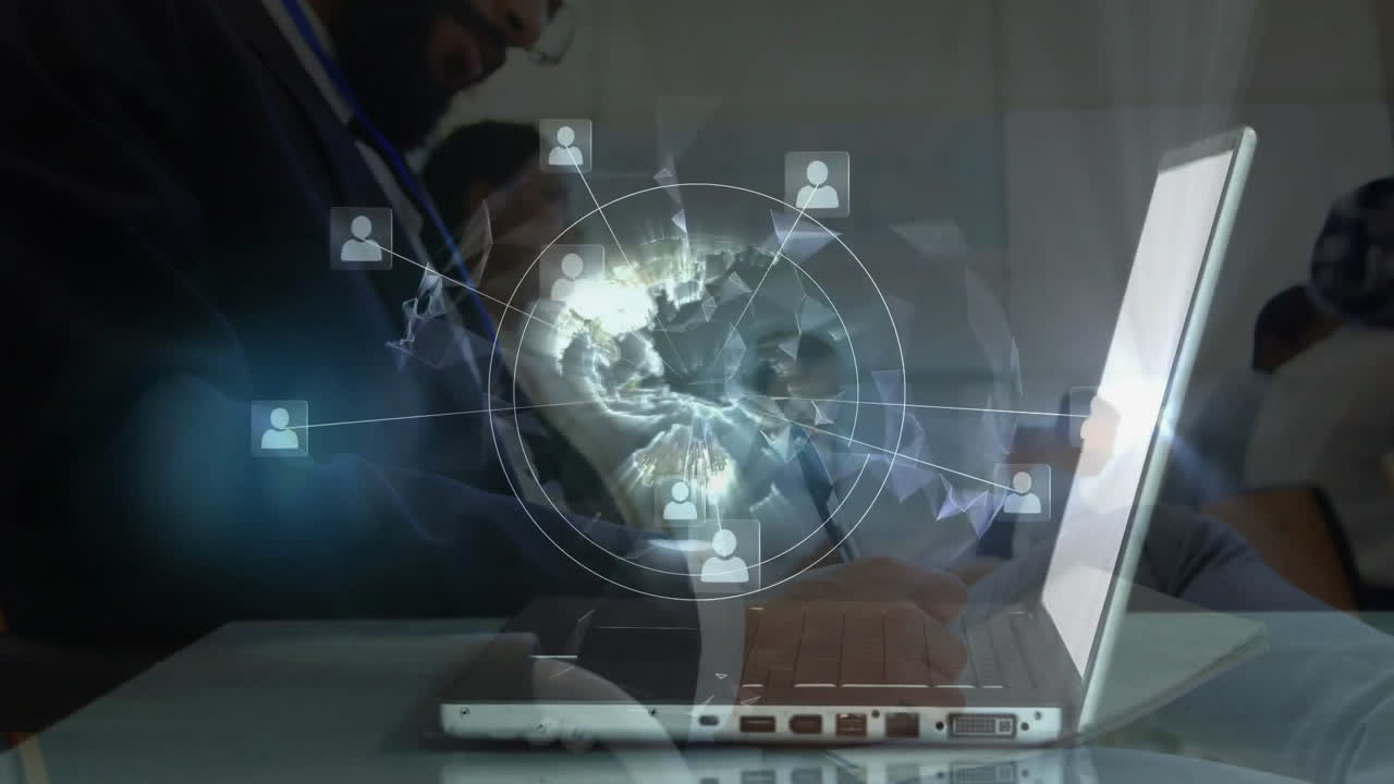 Man wearing glasses typing on laptop in tech office, with holographic globe and network icons