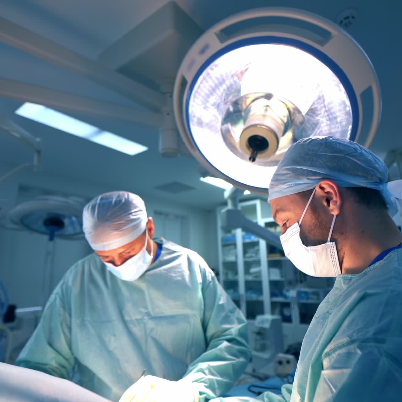 Team di chirurghi uomini al lavoro in una sala operatoria. Il primario utilizza strumenti in metallo durante l'intervento. Sfondo sfocato