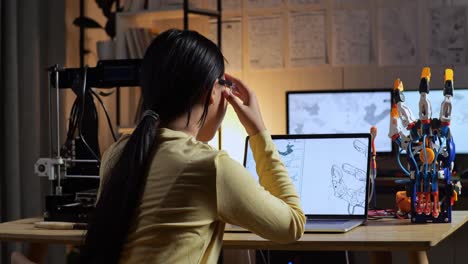 3d 프린팅으로 키보그 손을 디자인하는 동안 두통을 겪는 십대 아시아 소녀의 뒷면