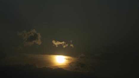 the beautiful yellow sun setting behind the clouds - time lapse