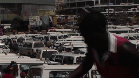 烏干達坎帕拉 (kampala) 一座擁<unk>的停車場上,小型巴士乘客忙碌地行走.