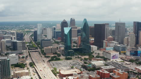 Panorama-curve-shot-of-downtown-skyscrapers.-Tall-buildings-among-lower-ones-and-busy-multi-lane-highway.-Dallas,-Texas,-US