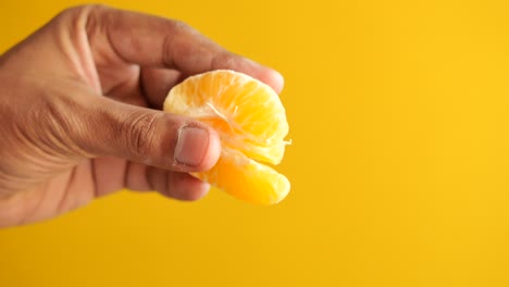 close up of holding slice of orange fruit ,