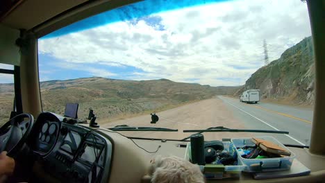 punto de vista del pasajero en una clase grande un vehículo recreativo mientras se fusiona de nuevo con la carretera las tierras altas de okanogan del estado central norte de washington con un perro labradoodle en primer plano