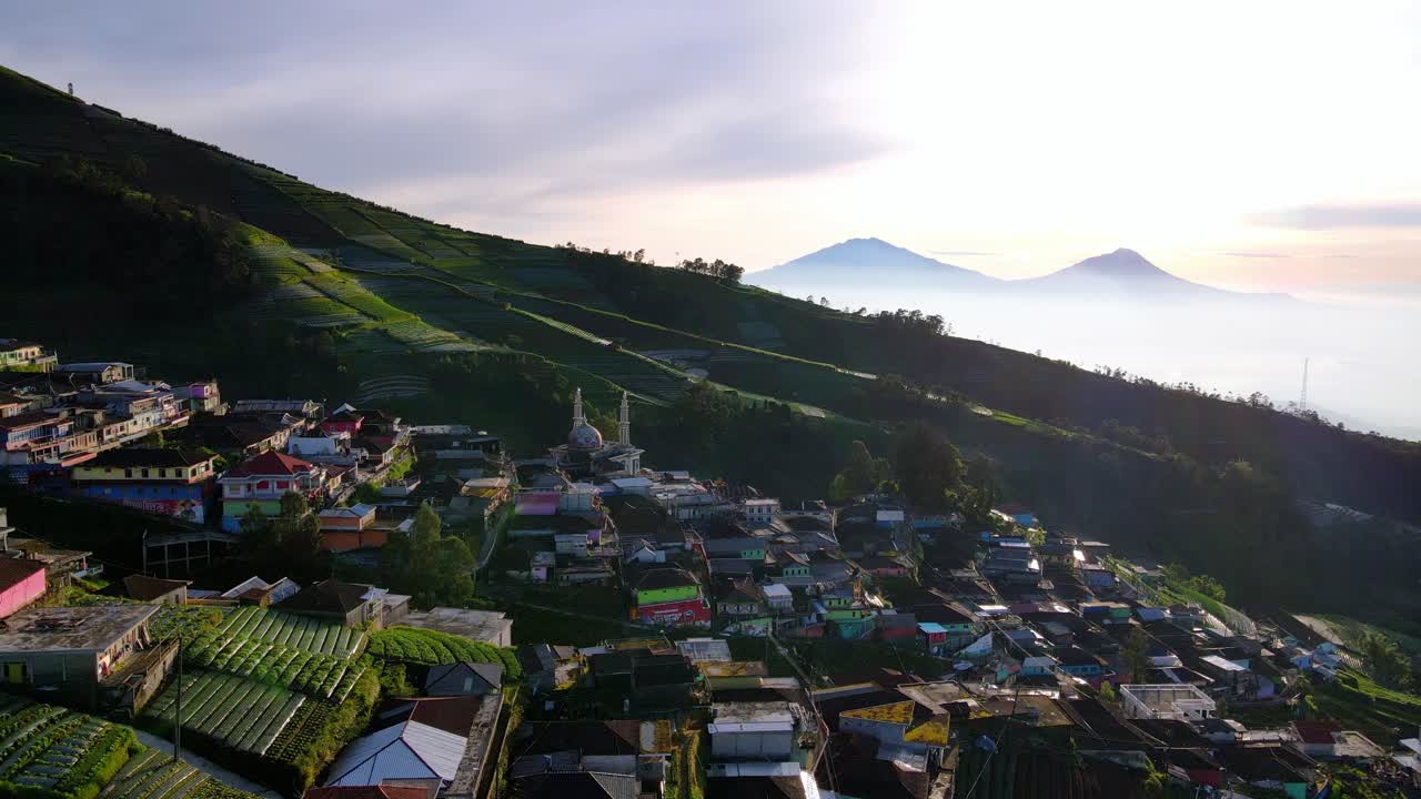 vista aérea del hermoso pueblo butuh con mezquita en el monte sumbing, indonesia durante la puesta de sol
