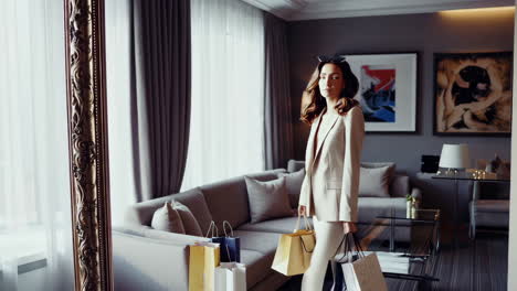 stylish woman in a suit trying on sunglasses in a luxury hotel room