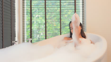 A-young-beautiful-woman-relaxes-in-a-spa-like-tub-as-she-takes-a-luxurious-bubble-bath