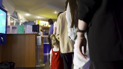 people queuing at a cinema ticket counter