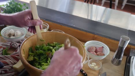 mixing the salad with wooden utensils