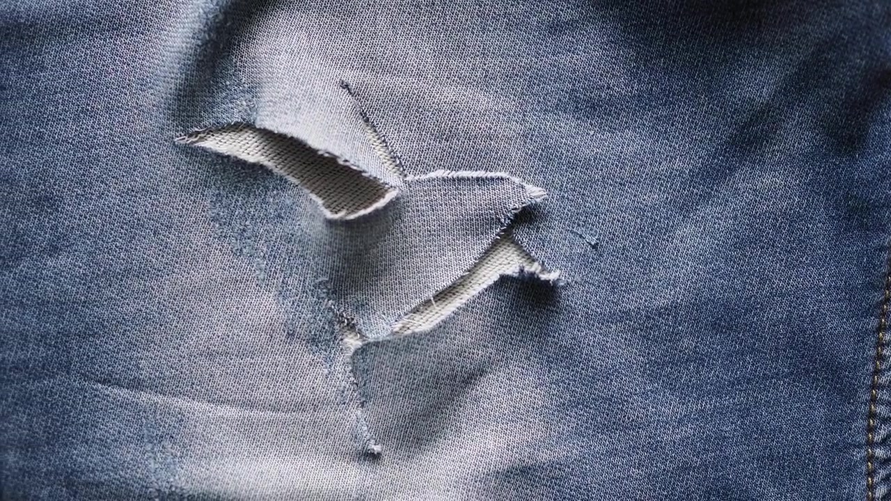 Close-up of Ripped Blue Denim Jeans Fabric