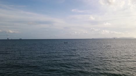 Drone-Aéreo-Hacia-Adelante-Tiro-En-Movimiento-Volando-Sobre-Un-Barco-De-Pesca-De-Cola-Larga-Que-Pasa-A-Través-Del-Mar-Profundo-A-Lo-Largo-De-La-Playa-De-Ao-Nang,-Krabi,-Tailandia