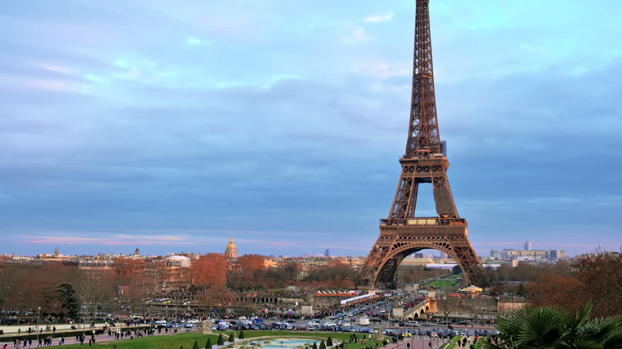 View of the Eiffel Tower in Paris from the Trocadero Square at sunset, France. Jena Bridge with multiple people and cars, cityscape