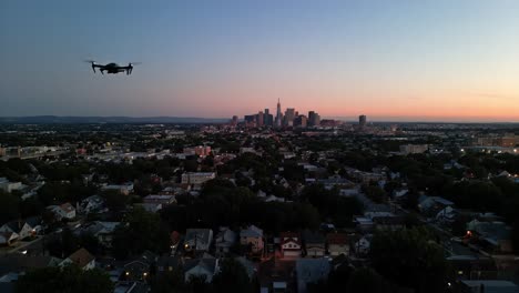 drone view of suburban area with city skyline at dusk