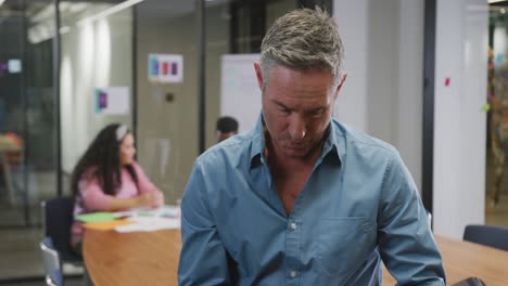 Portrait-of-happy-caucasian-businessman-looking-at-camera-at-office