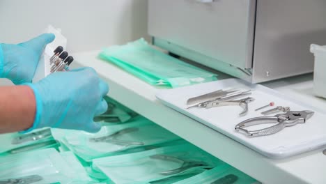 pedicure assistant prepares nail drill nozzles to tray with other pedicure tools