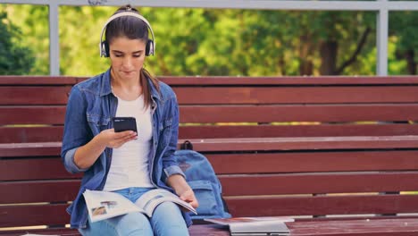 mujer morena satisfecha usando teléfono inteligente y escuchando música