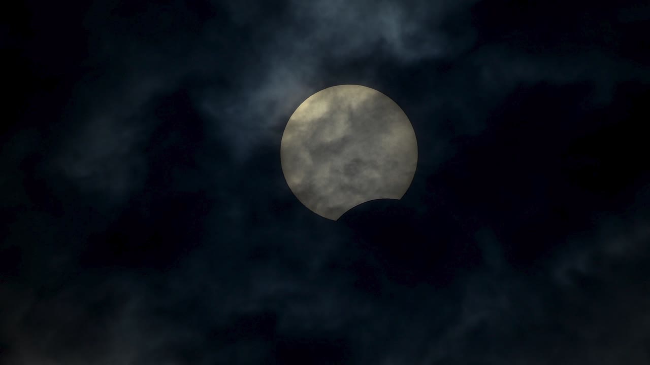 Eclipse solar HDR dramático pela lua em céu nublado, vídeo 4K real de eclipse solar.