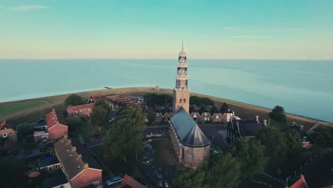 a historic church in a coastal village at sunrise, tranquil and picturesque, aerial view