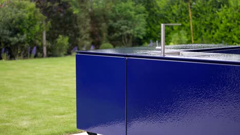 outside blue enamel kitchen in garden with water tap