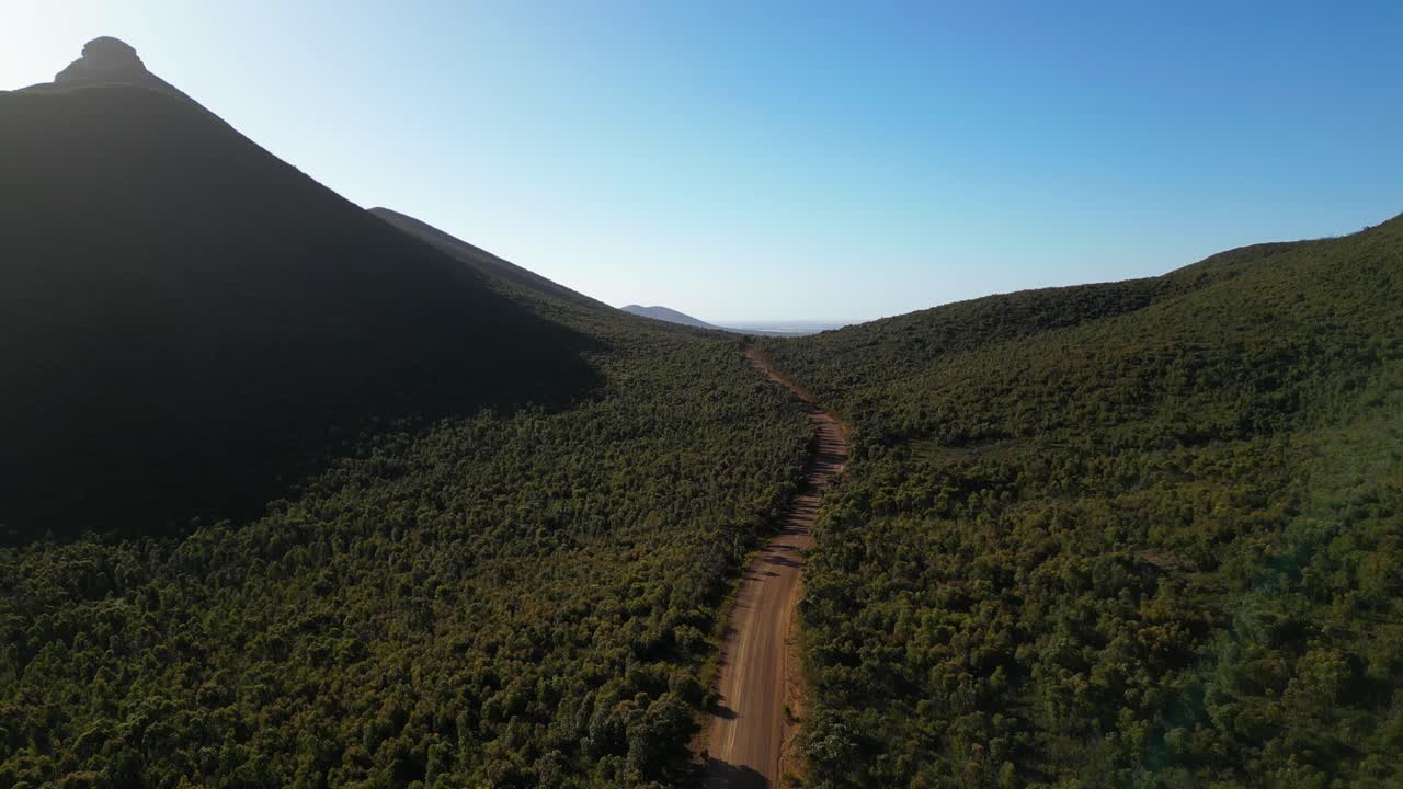 Ripresa aerea di una strada sterrata vuota che attraversa le montagne nell'outback australiano.