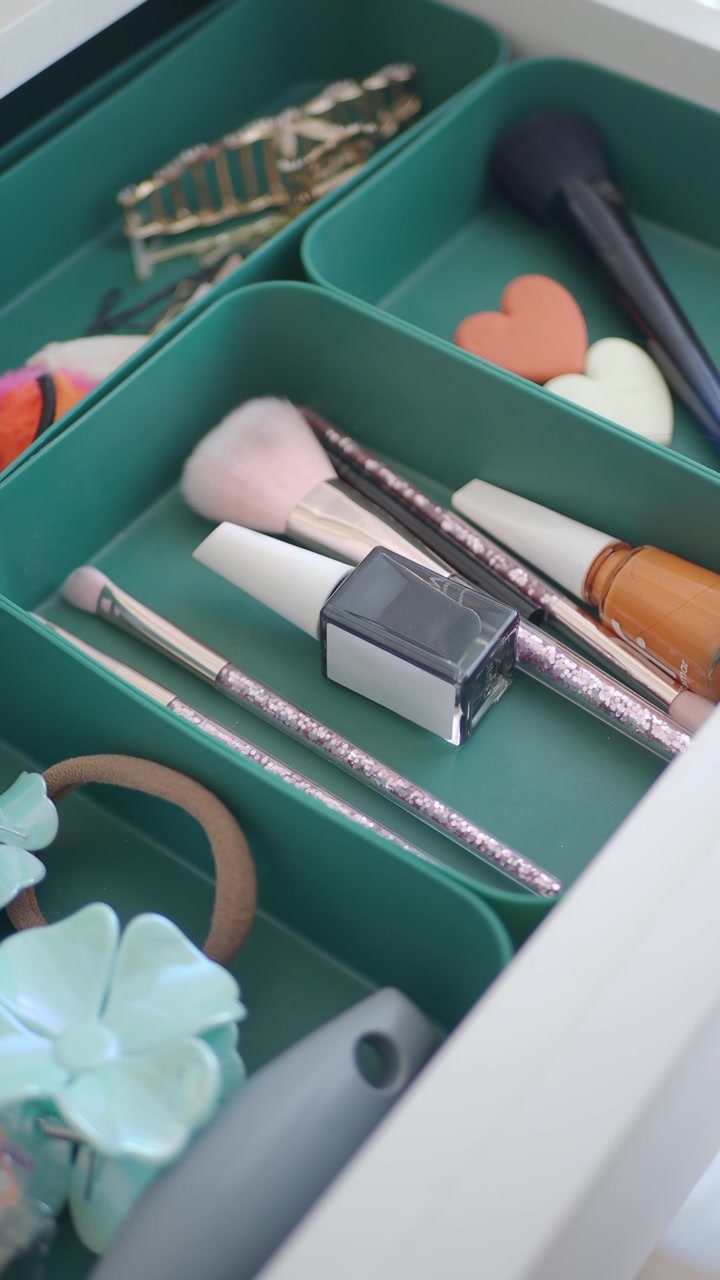 Mano che prende uno smalto per unghie da un cassetto per il trucco organizzato