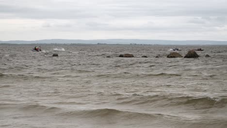 Support-vessel-boat-leads-currach-irish-boats-racing-through-ocean,-galway