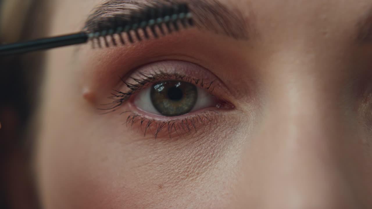 Close-up of a person applying mascara to their eyelashes