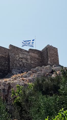 greek flag flying over the acropolis in athens