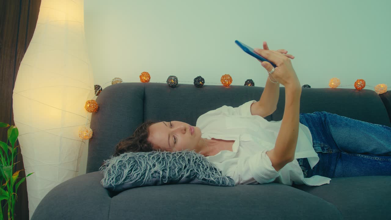 소파에서 셀피를 찍는 여자