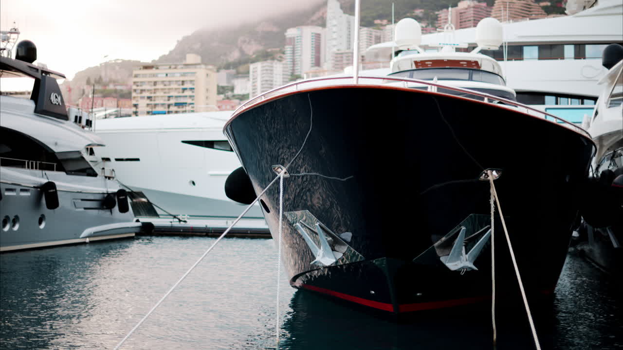 View of boats docked in the Monaco Marina with the skyline of the city on the background