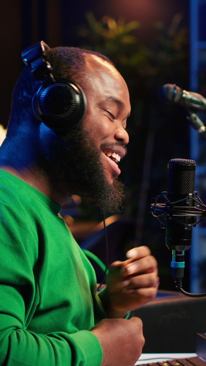 Glad afroamerikansk mand optager podcast i studie
