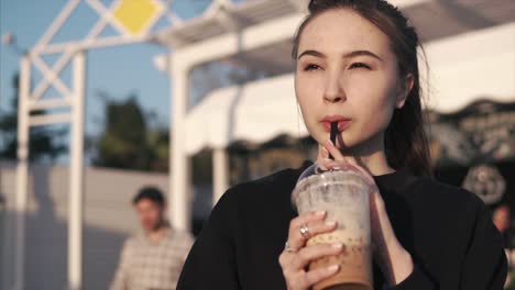 young woman enjoying a drink outdoors