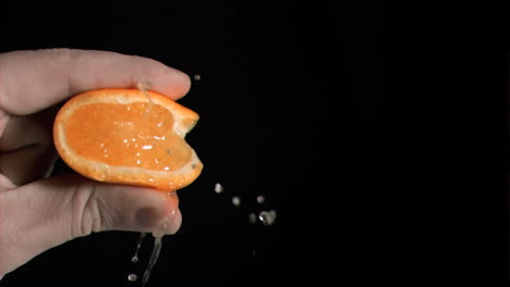 orange being squeezed in super slow motion