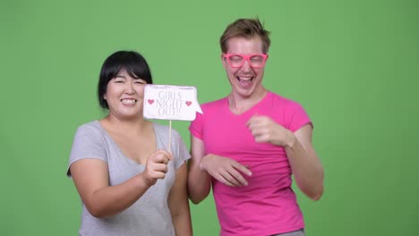 overweight asian woman and young gay man holding paper sign together