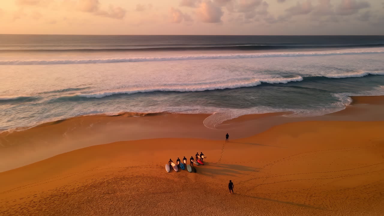 Surfers on a beach at sunrise or sunset
