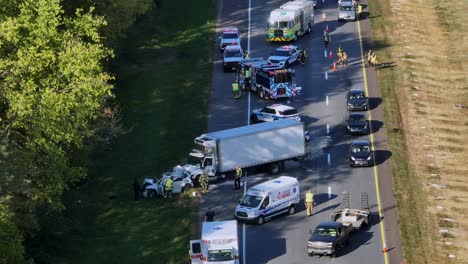 cars overtaking on street after vehicle accident in america. firemen cleaning highway after crash. aerial static shot. injured people on sunny autumnal day in american suburb town.