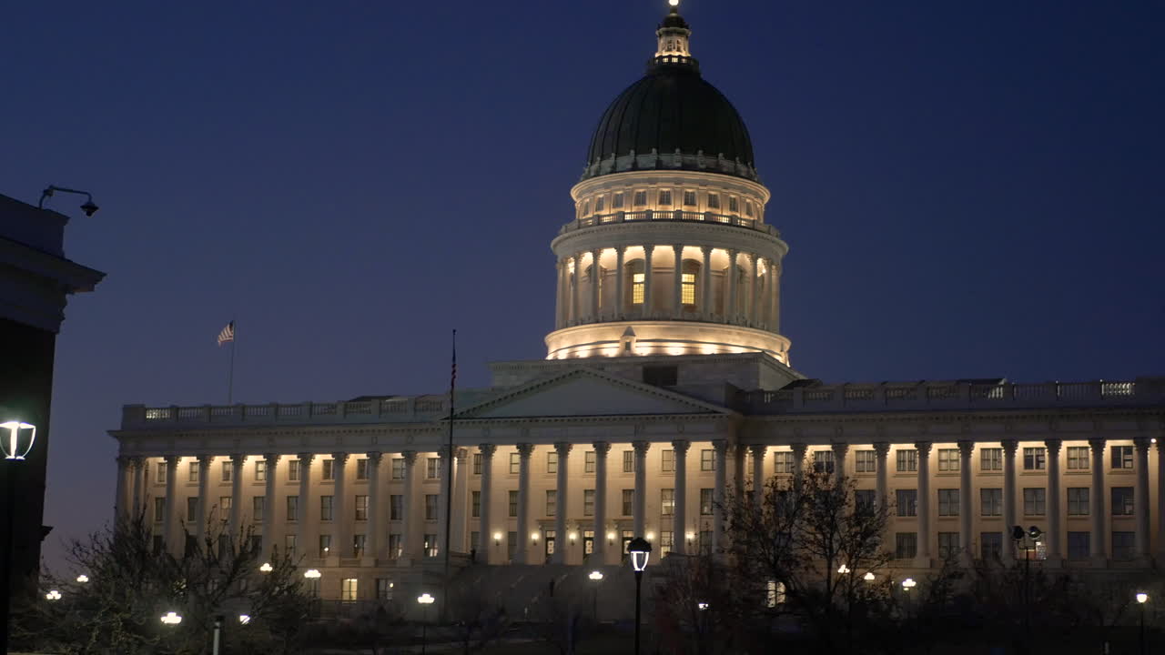 A panning shot of the The State of Utah Capitol building at Salt Lake City during the night with its lights on.