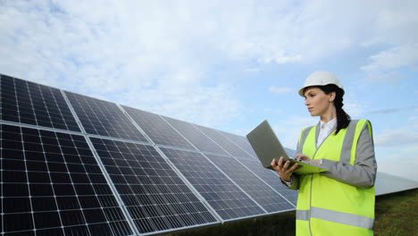 joven ingeniera caucásica usando laptop en panel solar