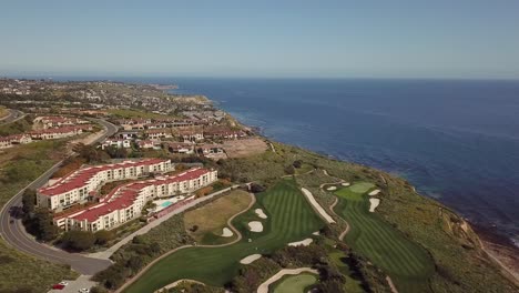 4K-Drone-Shot-of-Trump-National-Golf-Club-in-Rancho-Palos-Verdes,-California-on-the-Pacific-Ocean-with-Beachfront-Estates-at-Sunset-on-a-Warm,-Sunny-day