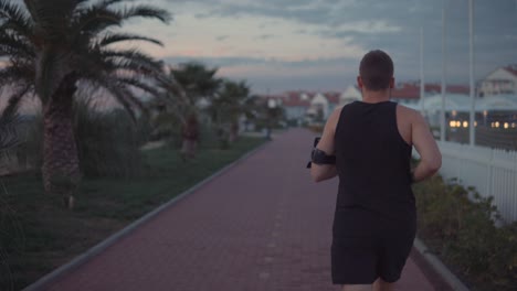 man running on a coastal path at sunset