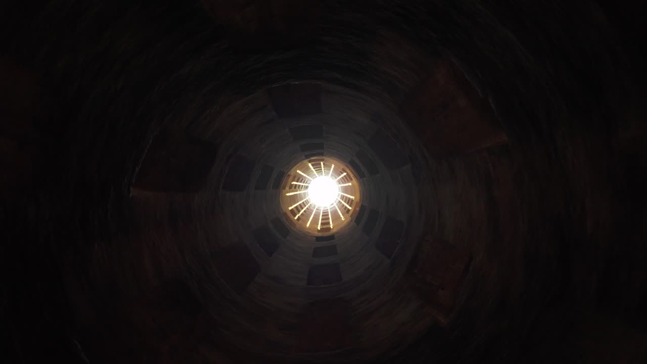 Dark, spinning view inside St. Patrick's Well looking up, Orvieto, Italy