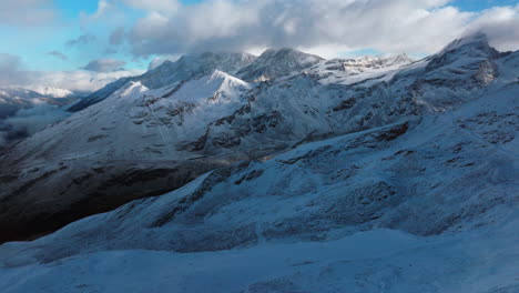 Sunset-blue-hour-cloudy-stunning-Gornergrat-Zermatt-Glacier-ice-crevasse-river-Swiss-Alps-top-The-Matterhorn-summit-ski-resort-landscape-scenery-aerial-drone-autumn-Railway-Switzerland-pan-left-motion