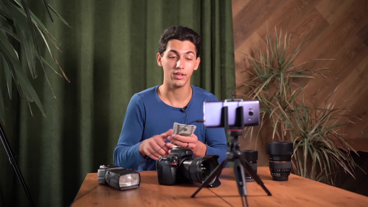 capacitación en video para fotógrafos principiantes, cursos en línea. un hombre musulmán tiene un paquete de billetes de cien dólares en sus manos y cuenta dinero. concepto de negocio de información y cursos de venta en línea.