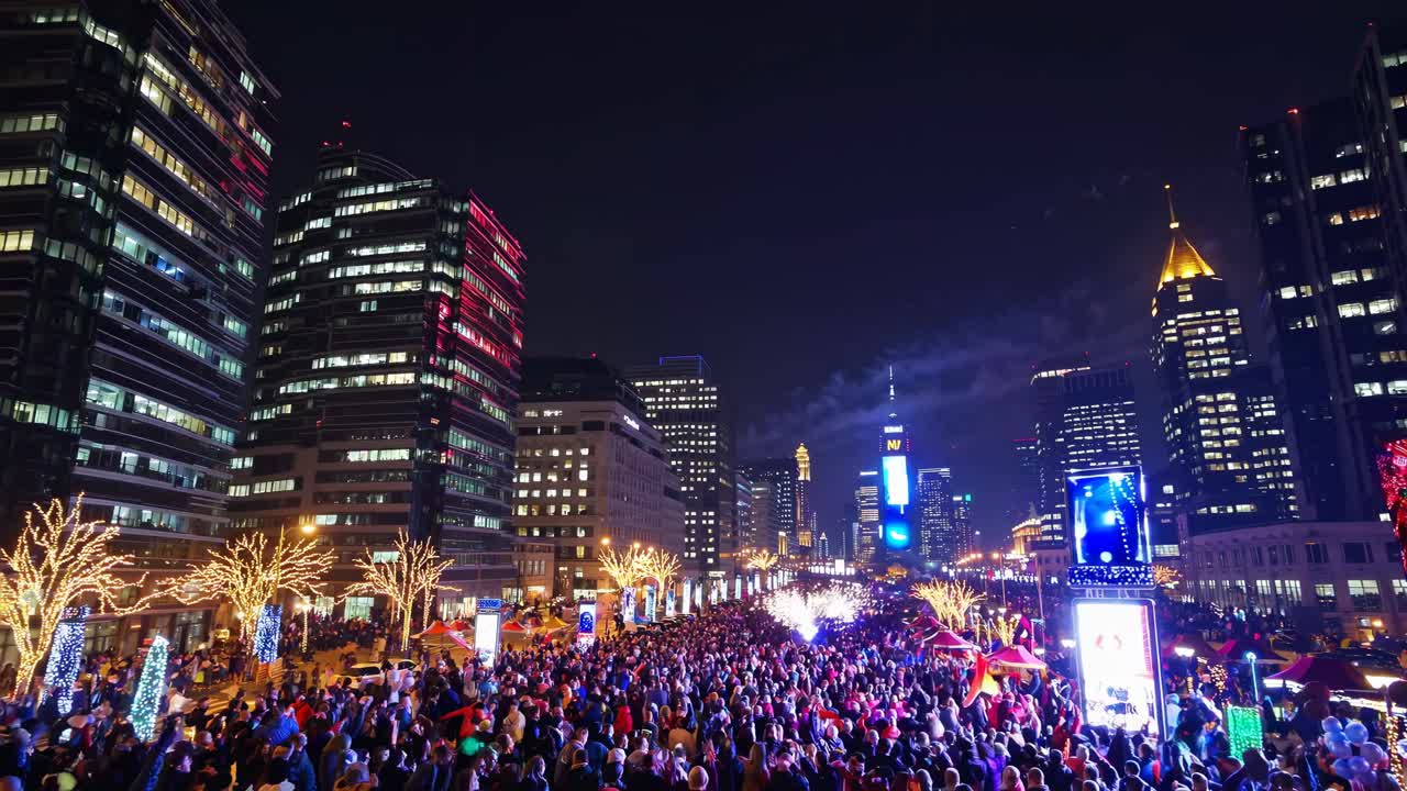 Vibrant cityscape at night from a high angle, capturing a bustling street filled with people