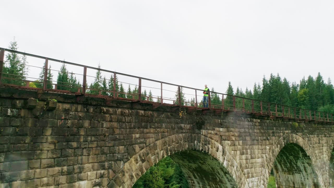 숲 속 의 오래된 돌 의 철도 다리 에 있는 사람