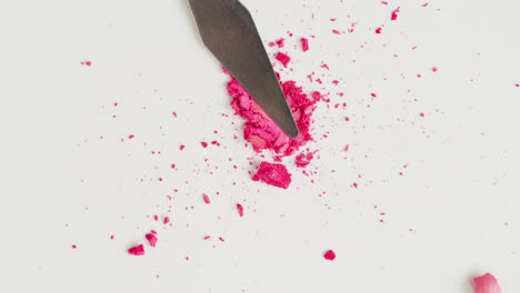 pink eyeshadow powder spilled from a spatula
